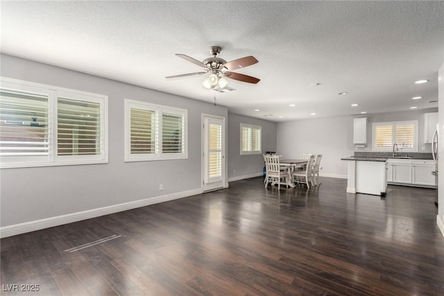 unfurnished dining area with a wealth of natural light, dark wood finished floors, baseboards, and recessed lighting