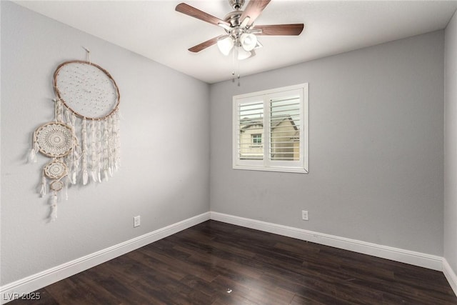 spare room with dark wood-type flooring, ceiling fan, and baseboards