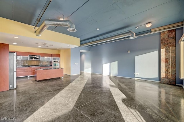 interior space with baseboards, visible vents, and freestanding refrigerator