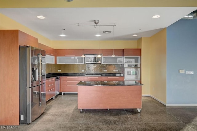 kitchen featuring dark countertops, tasteful backsplash, visible vents, and appliances with stainless steel finishes