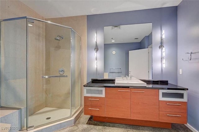 full bathroom with vanity, a shower stall, and visible vents