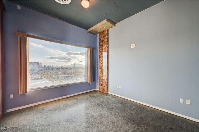 empty room featuring speckled floor and baseboards