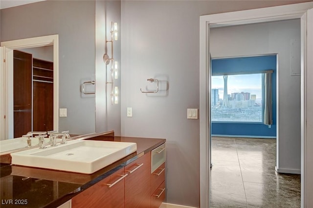 bathroom featuring vanity, a city view, and baseboards