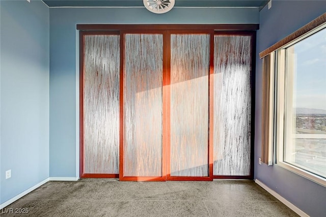 spare room featuring baseboards and carpet floors