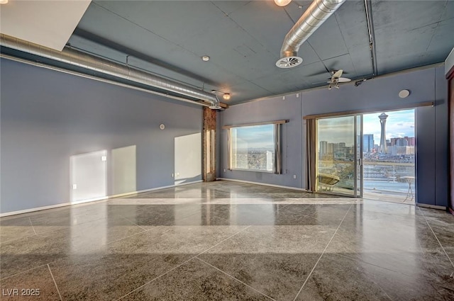 empty room featuring visible vents, a view of city, and baseboards