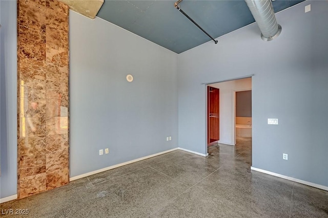 empty room with speckled floor and baseboards