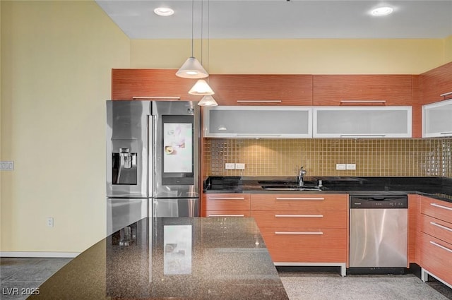 kitchen with a sink, hanging light fixtures, stainless steel appliances, modern cabinets, and backsplash