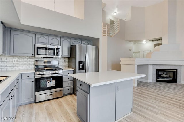 kitchen featuring light wood-style floors, gray cabinets, and appliances with stainless steel finishes