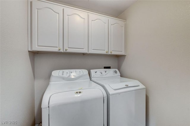 clothes washing area with washer and dryer and cabinet space