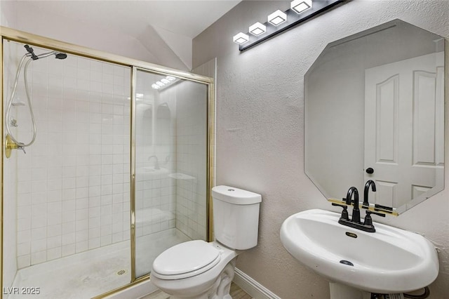 full bathroom with a shower stall, toilet, a textured wall, and a sink