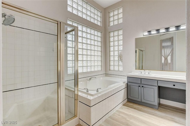 full bathroom with wood finished floors, vanity, a bath, and a shower stall