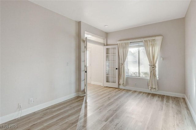 unfurnished room featuring baseboards and wood finished floors