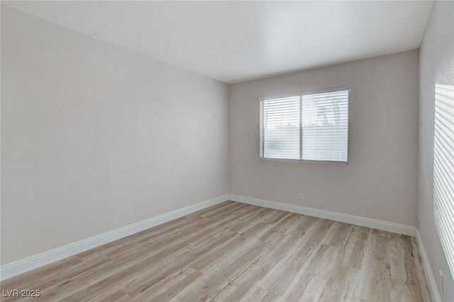 spare room with light wood-style floors and baseboards