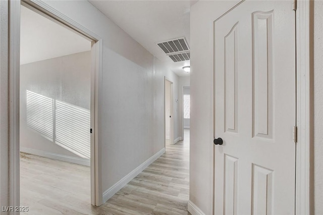 corridor with visible vents, baseboards, and light wood-style flooring