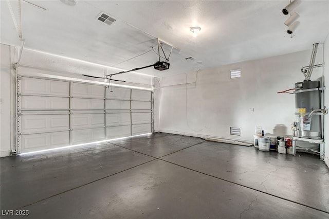 garage with secured water heater, a garage door opener, and visible vents