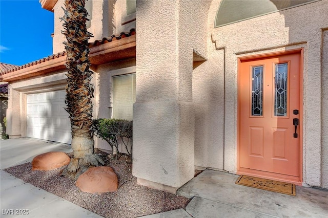 property entrance featuring stucco siding and a garage