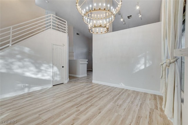 spare room with visible vents, baseboards, and wood finished floors