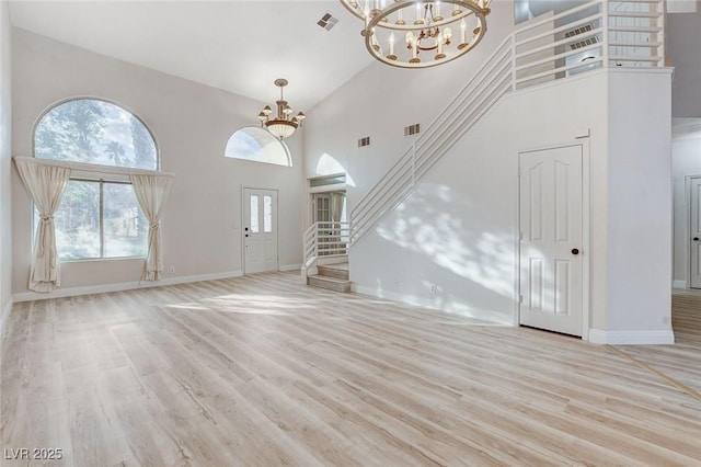 unfurnished living room featuring light wood finished floors, visible vents, stairs, and an inviting chandelier