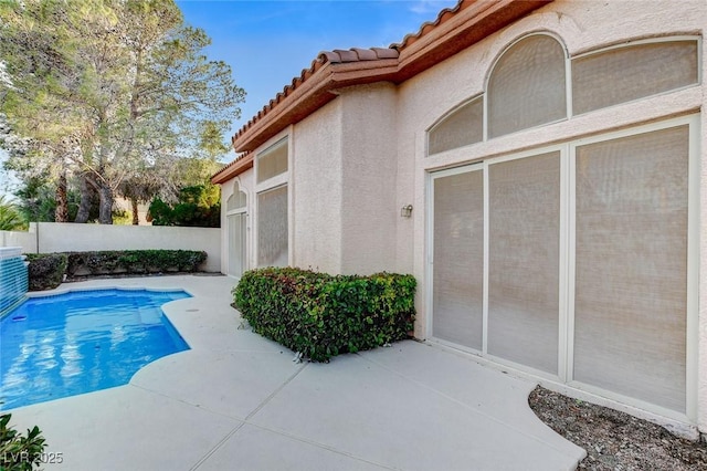 view of swimming pool with a patio area, a fenced in pool, and fence