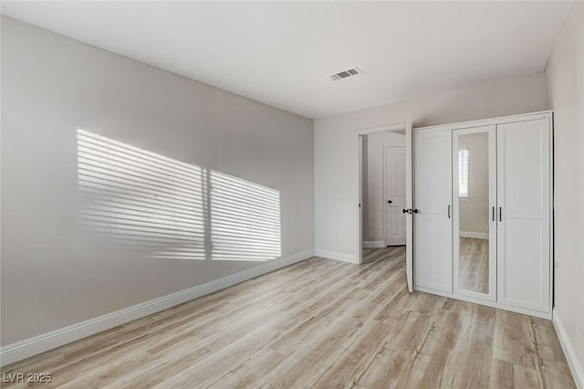 unfurnished bedroom featuring visible vents, baseboards, and light wood-style flooring