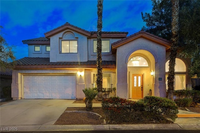 view of front of home with a tile roof, stucco siding, concrete driveway, and a garage