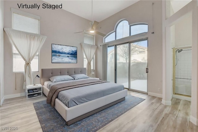 bedroom with light wood-type flooring, a towering ceiling, and access to outside