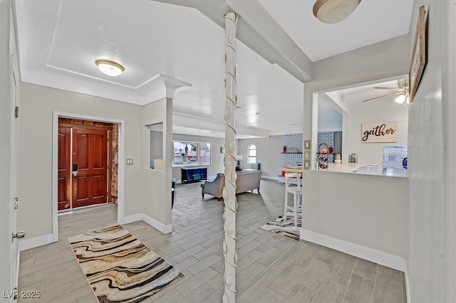 foyer with a ceiling fan, wood finish floors, and baseboards