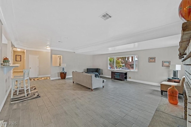 living room with wood tiled floor, visible vents, and baseboards