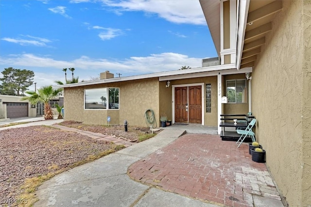 entrance to property featuring stucco siding