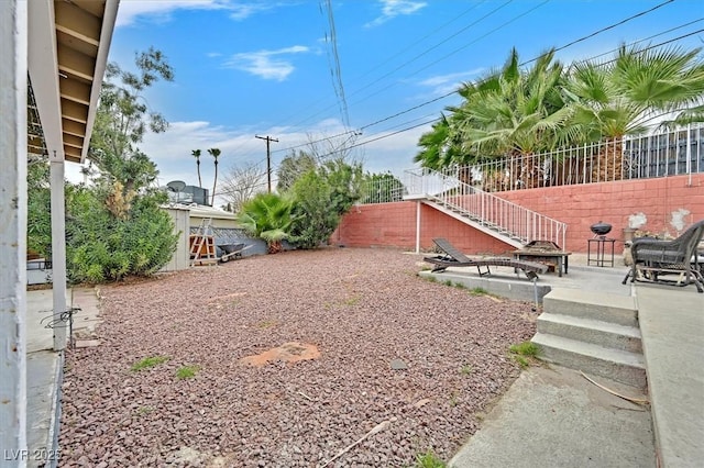 view of yard with a fire pit, a patio area, and fence