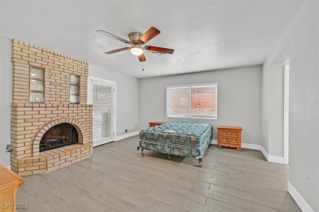 bedroom featuring a fireplace, baseboards, and wood finished floors