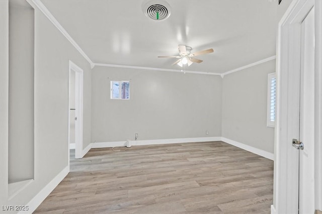 empty room featuring light wood finished floors, ceiling fan, visible vents, and crown molding