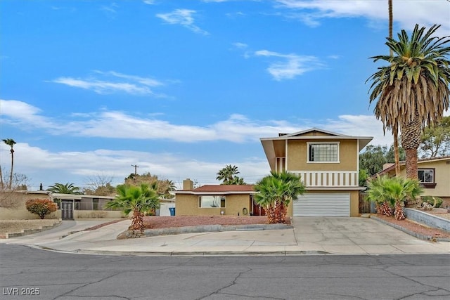 view of front of house featuring a garage, concrete driveway, and stucco siding