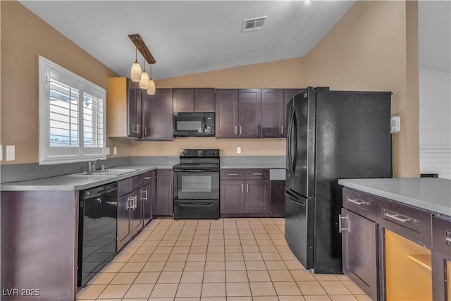 kitchen featuring light countertops, lofted ceiling, light tile patterned flooring, black appliances, and a sink