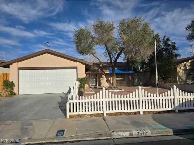 ranch-style home with an attached garage, driveway, a fenced front yard, and stucco siding