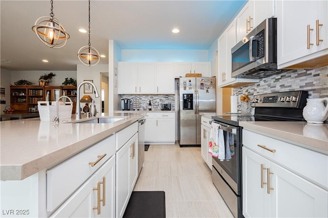 4560 E Cactus Canyon Dr, Pahrump, NV 89061 - kitchen with stainless steel appliances, hanging light fixtures, a sink, and white cabinets