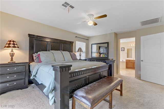 bedroom with visible vents, connected bathroom, light carpet, and ceiling fan