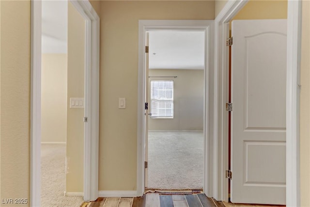 corridor featuring carpet and baseboards