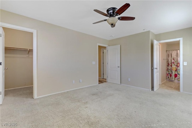 unfurnished bedroom featuring carpet, baseboards, and a walk in closet