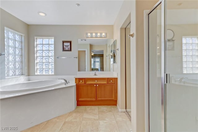 full bath featuring plenty of natural light, a garden tub, and a shower stall