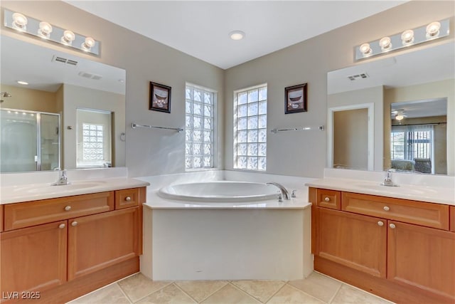 bathroom featuring plenty of natural light, a stall shower, visible vents, and a sink