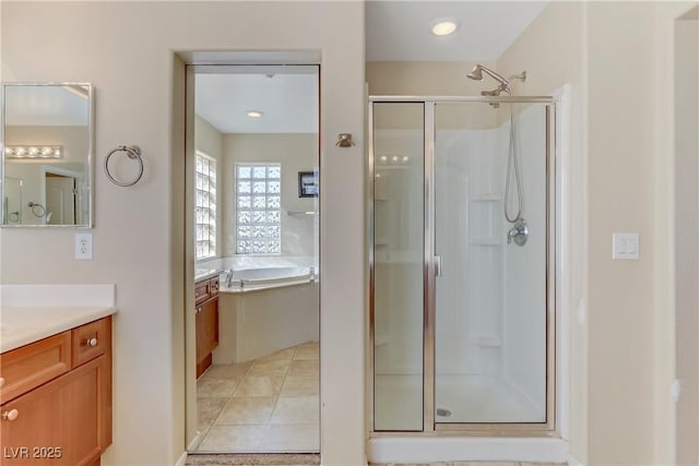 full bath with a stall shower, tile patterned flooring, vanity, and a bath