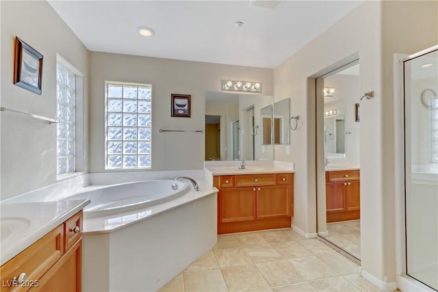 full bathroom with a stall shower, tile patterned flooring, a garden tub, and a sink