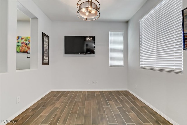 unfurnished room with wood finish floors and baseboards