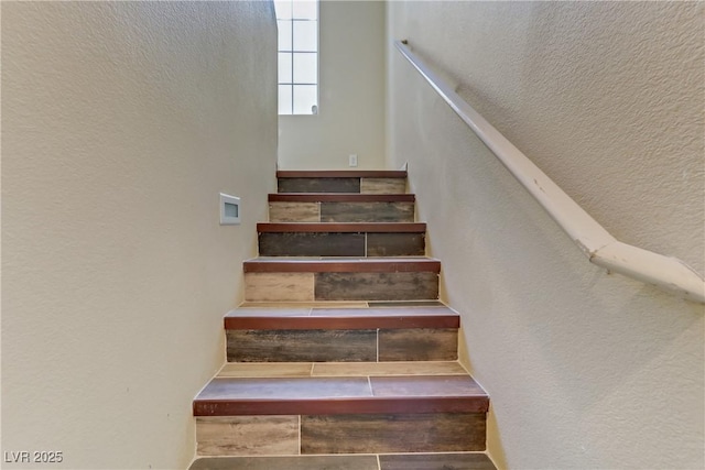 stairway featuring a textured wall