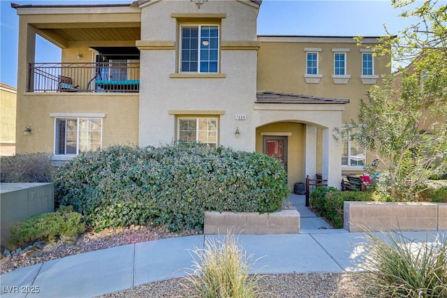 view of front of home featuring a balcony and stucco siding