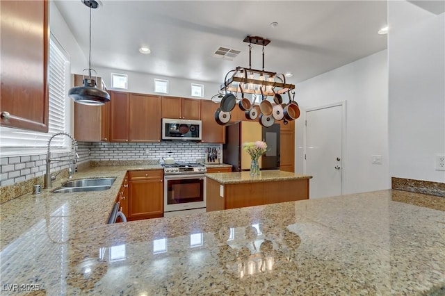 kitchen featuring tasteful backsplash, visible vents, light stone counters, appliances with stainless steel finishes, and a sink