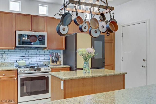 kitchen featuring light stone countertops, appliances with stainless steel finishes, and decorative backsplash