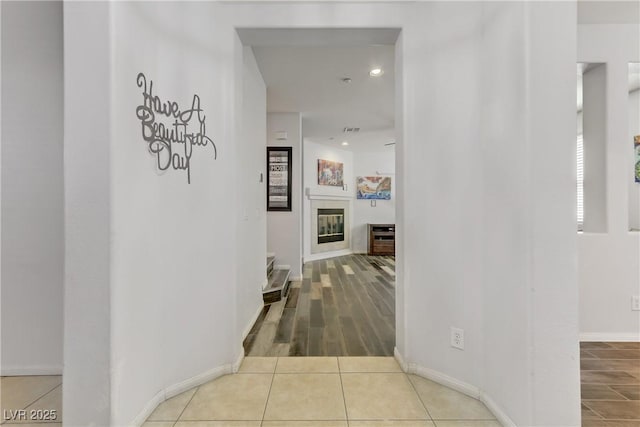 corridor with tile patterned flooring and baseboards