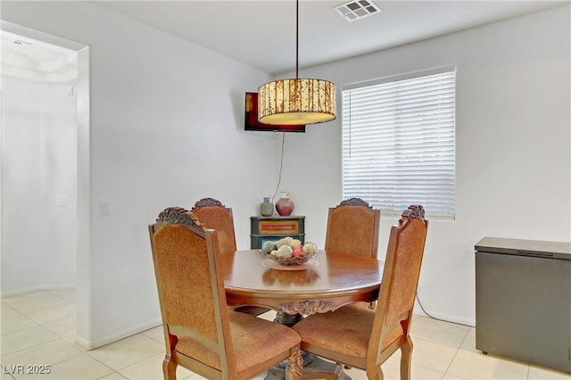 dining area featuring light tile patterned floors, baseboards, and visible vents